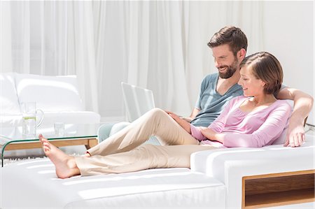 Couple using laptop on sofa in modern living room Foto de stock - Sin royalties Premium, Código: 6113-07790571
