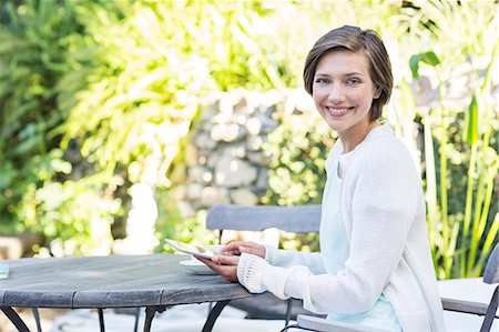 relaxing in backyard - Woman using digital tablet at table outdoors Stock Photo - Premium Royalty-Free, Code: 6113-07790572