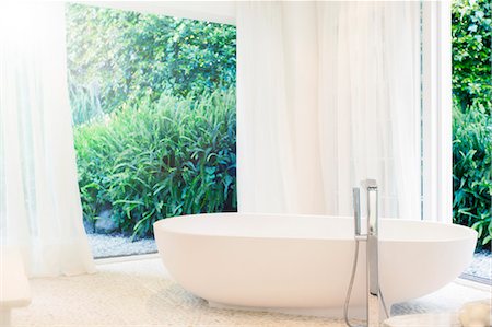 Bathtub, curtains, and windows in modern bathroom Foto de stock - Sin royalties Premium, Código: 6113-07790574