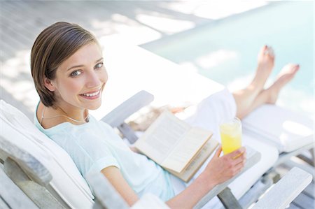 High angle view of woman reading and drinking juice by swimming pool Foto de stock - Sin royalties Premium, Código: 6113-07790521