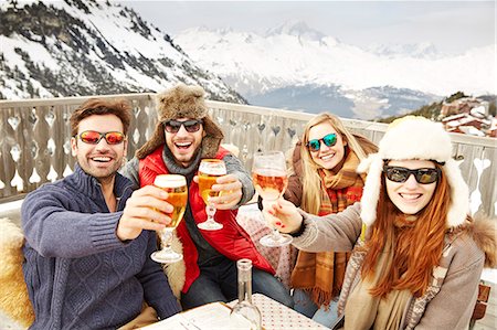 Friends celebrating with drinks in the snow Stock Photo - Premium Royalty-Free, Code: 6113-07790644