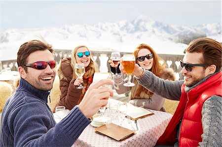 Friends celebrating with drinks in the snow Stock Photo - Premium Royalty-Free, Code: 6113-07790663