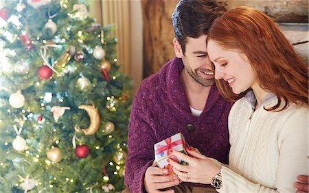 simsearch:6113-07790673,k - Couple exchanging gifts on Christmas Photographie de stock - Premium Libres de Droits, Code: 6113-07790673