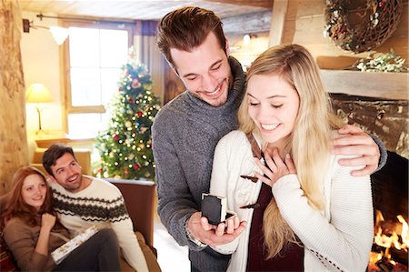 Man giving girlfriend jewelry for Christmas Stock Photo - Premium Royalty-Free, Code: 6113-07790670