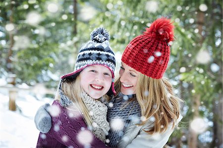 focus on foreground forest - Mother and daughter hugging in the snow Stock Photo - Premium Royalty-Free, Code: 6113-07790622