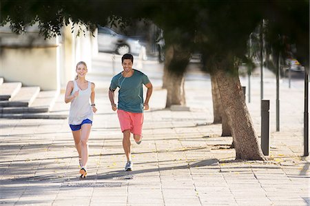 fitness couple - Couple running through city streets together Stock Photo - Premium Royalty-Free, Code: 6113-07790741