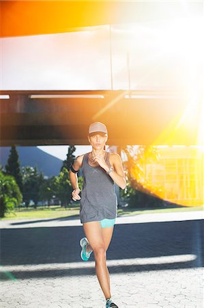single caucasian sports woman not looking at camera - Woman running through city streets Stock Photo - Premium Royalty-Free, Code: 6113-07790761