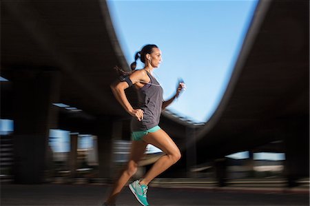 simsearch:6113-06720362,k - Woman running through city streets Foto de stock - Sin royalties Premium, Código: 6113-07790780