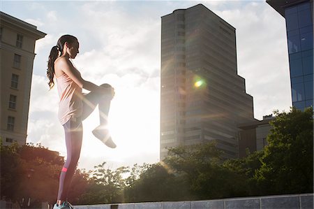 standing on one leg - Woman stretching before exercising on city street Photographie de stock - Premium Libres de Droits, Code: 6113-07790786