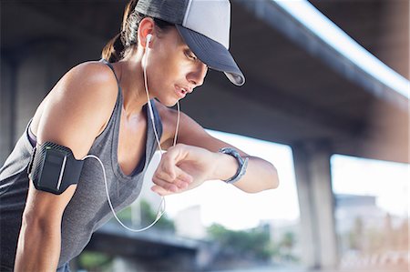 reloj de sol - Woman looking at watch after exercising on city street Foto de stock - Sin royalties Premium, Código: 6113-07790799