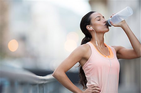 Woman drinking water after exercising on city street Stock Photo - Premium Royalty-Free, Code: 6113-07790811