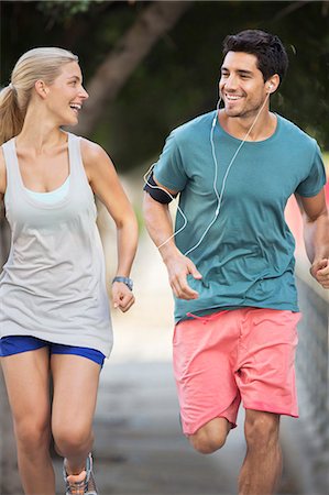 Couple running through city streets together Stock Photo - Premium Royalty-Free, Code: 6113-07790834