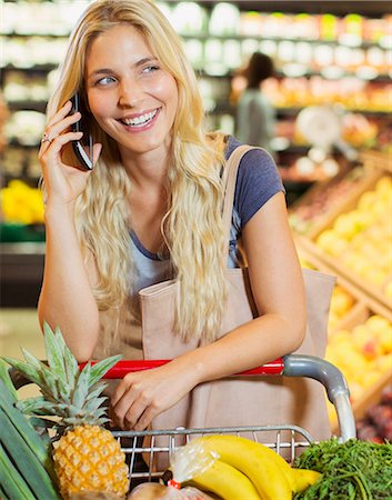 Woman talking on cell phone while shopping in grocery store Foto de stock - Sin royalties Premium, Código: 6113-07790956