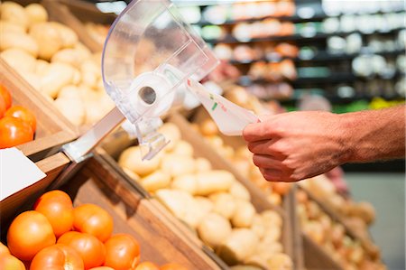 Close up of man taking plastic bag in produce section of grocery store Stock Photo - Premium Royalty-Free, Code: 6113-07790973