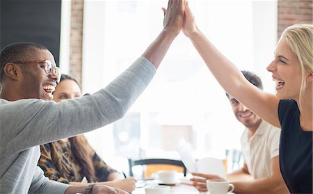 successful business woman arms raised with joy - Business people high fiving at meeting in cafe Photographie de stock - Premium Libres de Droits, Code: 6113-07790916