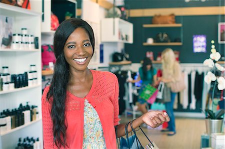 simsearch:6113-07791123,k - Woman smiling in clothing store Photographie de stock - Premium Libres de Droits, Code: 6113-07791062