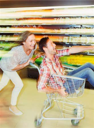 simsearch:6113-07542414,k - Blurred view of couple playing in grocery store Stock Photo - Premium Royalty-Free, Code: 6113-07791038