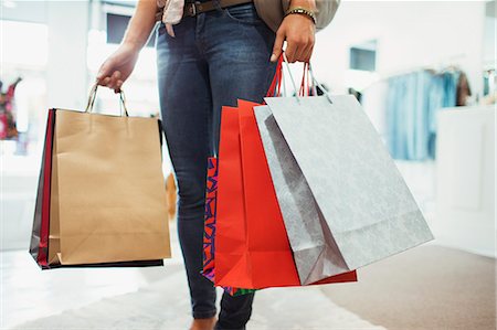 shopping bag - Woman carrying shopping bags in clothing store Stock Photo - Premium Royalty-Free, Code: 6113-07791039