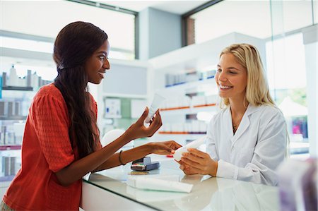 Woman discussing skincare product with pharmacist in drugstore Photographie de stock - Premium Libres de Droits, Code: 6113-07791146