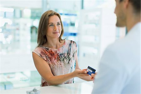 retail - Woman paying with credit card in drugstore Stock Photo - Premium Royalty-Free, Code: 6113-07791159