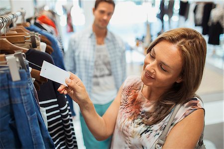 simsearch:649-08232742,k - Woman checking tag while shopping in clothing store Stock Photo - Premium Royalty-Free, Code: 6113-07791165