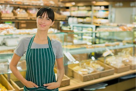 Clerk smiling in deli section of grocery store Stock Photo - Premium Royalty-Free, Code: 6113-07791134