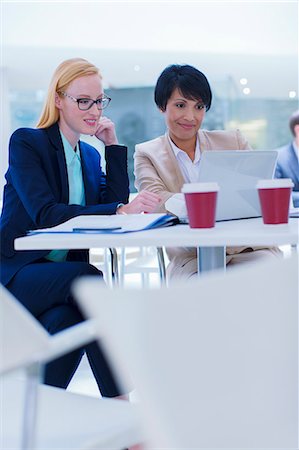 simsearch:6113-07790909,k - Businesswomen working on laptop at table Stock Photo - Premium Royalty-Free, Code: 6113-07791279