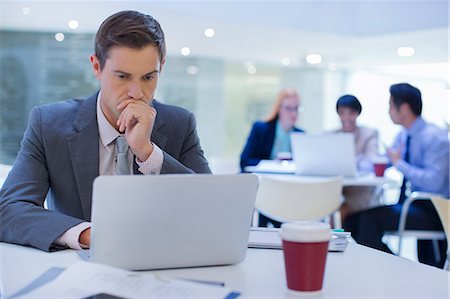 simsearch:6113-07790854,k - Businessman working on laptop at table Foto de stock - Royalty Free Premium, Número: 6113-07791299