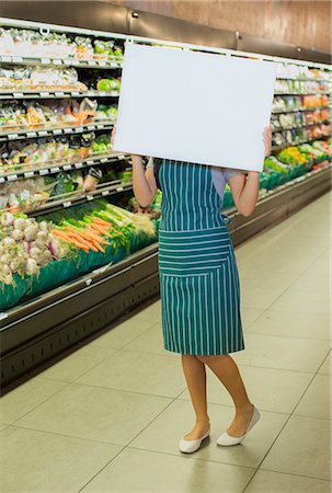 saleswoman caucasian - Clerk holding blank card in grocery store Photographie de stock - Premium Libres de Droits, Code: 6113-07791220