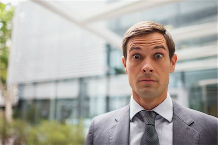 stress - Businessman with eyebrows raised outside office building Photographie de stock - Premium Libres de Droits, Code: 6113-07791397