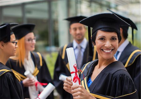 Student in cap and gown smiling with colleges Stock Photo - Premium Royalty-Free, Code: 6113-07791499