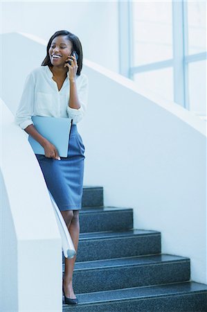 descended - Businesswoman walking on cell phone on stairs of office building Stock Photo - Premium Royalty-Free, Code: 6113-07791405