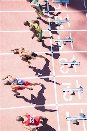 simsearch:6113-07730594,k - Sprinters taking off from starting blocks on track Stock Photo - Premium Royalty-Free, Code: 6113-07730443