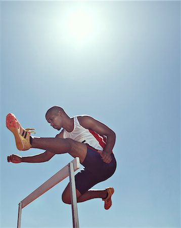 Track and field athlete clearing hurdle Foto de stock - Sin royalties Premium, Código: 6113-07730446