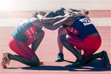 sports team huddle - Runners huddled on track Foto de stock - Sin royalties Premium, Código: 6113-07730475