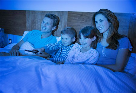 Family watching television in bed Stock Photo - Premium Royalty-Free, Code: 6113-07730575