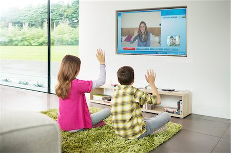 profesor (hombre y mujer) - Children video chatting on television in living room Foto de stock - Sin royalties Premium, Código: 6113-07730536