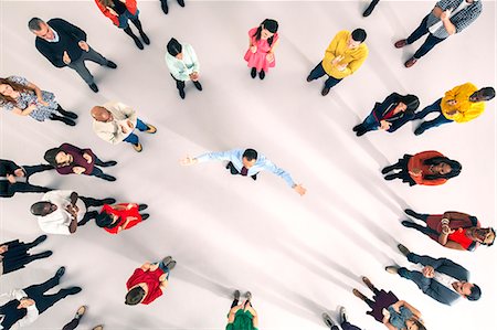 elevated view crowd - Crowd around businessman with arms outstretched Stock Photo - Premium Royalty-Free, Code: 6113-07730697