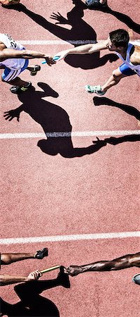 Relay runners handing off baton on track Stock Photo - Premium Royalty-Free, Code: 6113-07730608