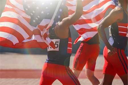 simsearch:6113-07588797,k - Track and field athletes holding American flags on track Foto de stock - Sin royalties Premium, Código: 6113-07730616