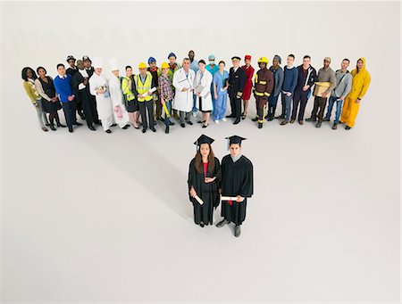 studio portrait above woman - Portrait of graduates with workers in background Stock Photo - Premium Royalty-Free, Code: 6113-07730630