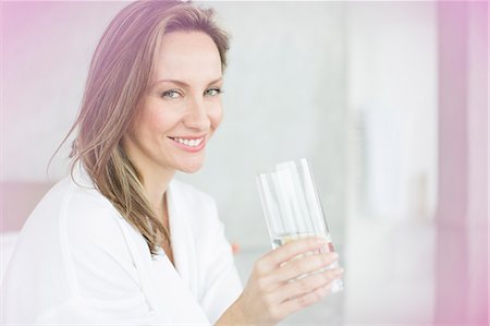 Woman having glass of water in bedroom Foto de stock - Sin royalties Premium, Código: 6113-07730745