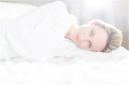 simsearch:6113-07242590,k - Woman in bathrobe laying on bed Foto de stock - Sin royalties Premium, Código: 6113-07730750