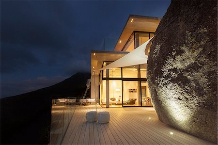 simsearch:6113-07730744,k - Illuminated modern house with rock feature and balcony Stock Photo - Premium Royalty-Free, Code: 6113-07730762