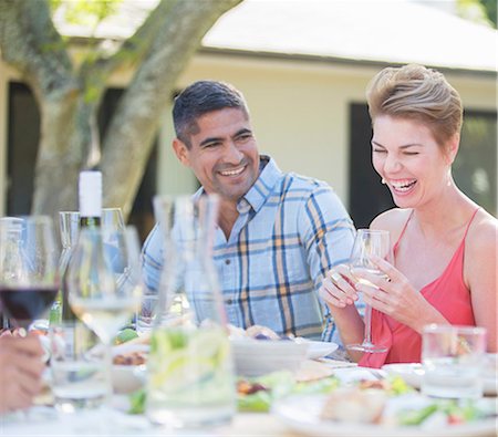 simsearch:6113-07730929,k - Couple laughing at table outdoors Stock Photo - Premium Royalty-Free, Code: 6113-07730872