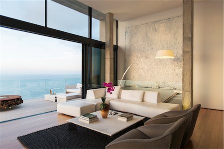 simsearch:6113-07730744,k - Modern living room overlooking ocean Photographie de stock - Premium Libres de Droits, Code: 6113-07730805
