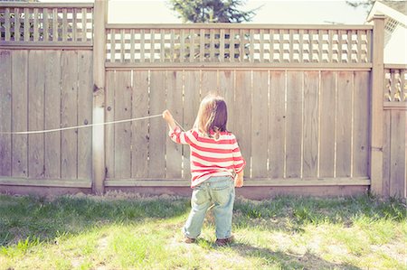 simsearch:6113-06753923,k - Baby girl playing with string in backyard Photographie de stock - Premium Libres de Droits, Code: 6113-07730810