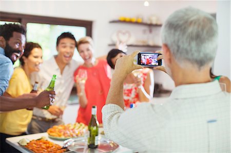 dinner and young adults - Friends taking picture together at party Stock Photo - Premium Royalty-Free, Code: 6113-07730834