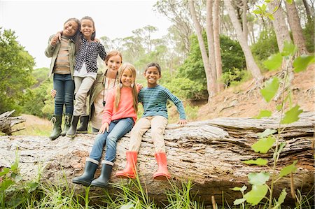 Students and teacher sitting on log in forest Stock Photo - Premium Royalty-Free, Code: 6113-07731157