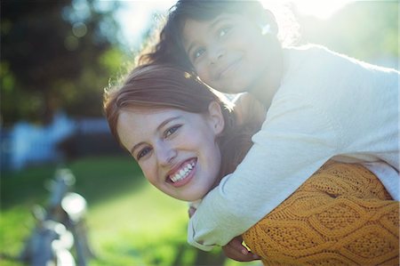 portrait of woman bonding with child - Mother carrying daughter on shoulders Stock Photo - Premium Royalty-Free, Code: 6113-07731167